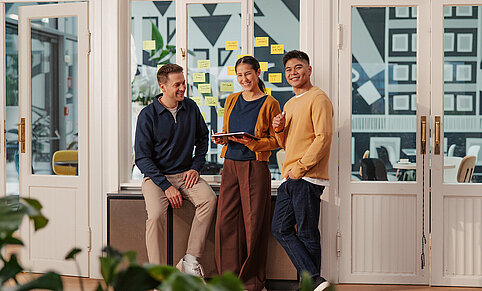 Teamwork im offenen Büro, Gruppe junger Kollegen, Austausch im agilen Team