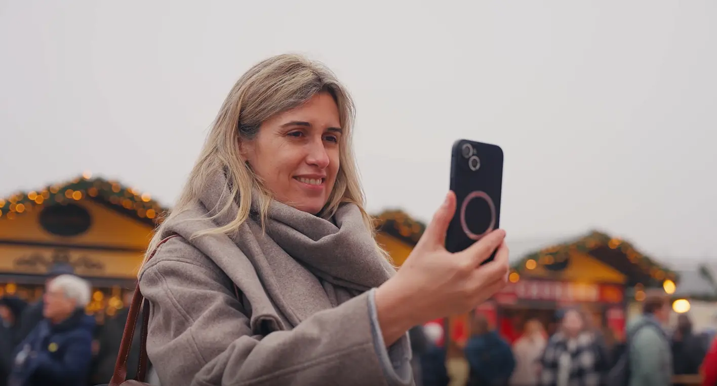 Izabella Bastos mit Smartphone auf dem Christkindlmarkt.