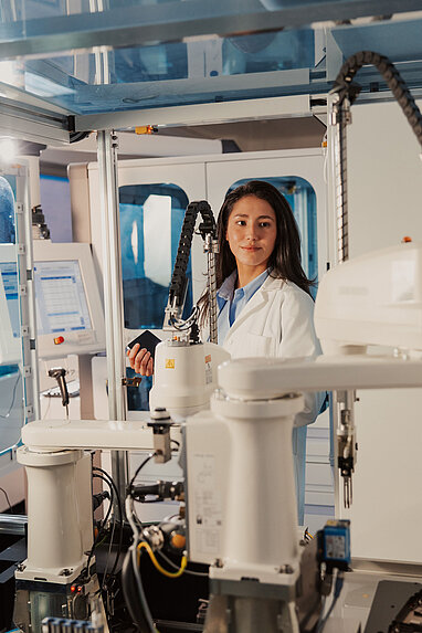 Life Sciences Österreich: eine internationale Fachkraft im Bereich Forschung und Entwicklung arbeitet in einem hochautomatisierten Labor
